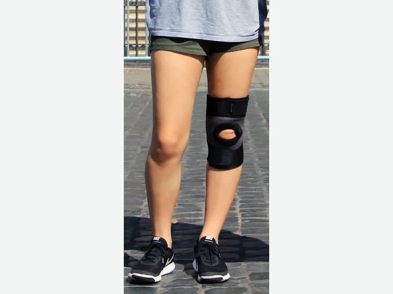 Orthopedic knee support brace fitted around a knee